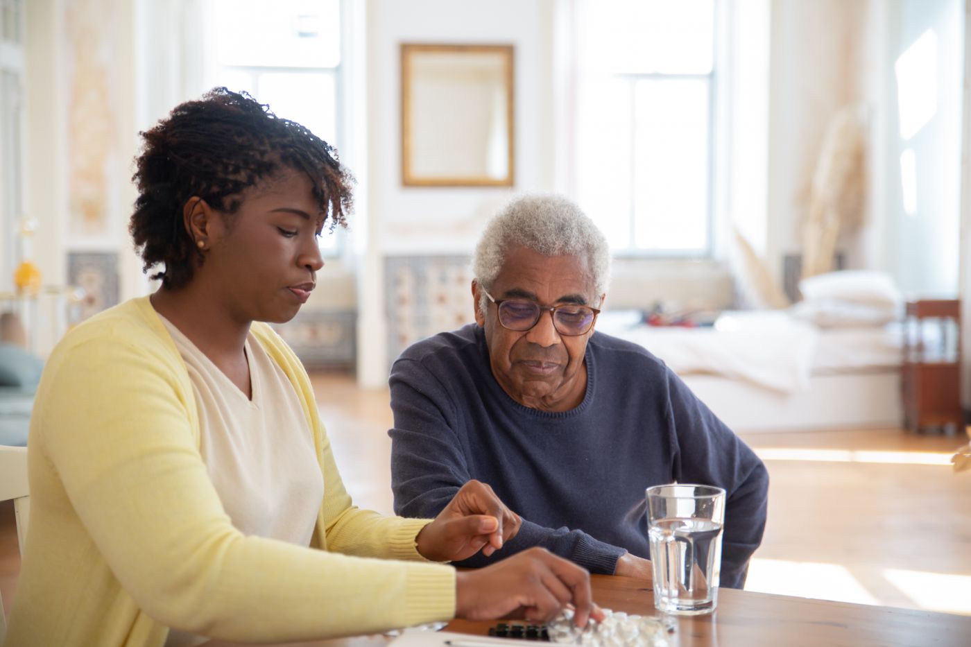 A support worker and an older individual enjoying a game together at home